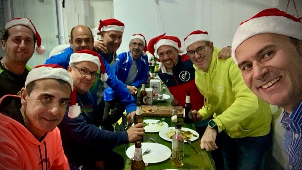 Amigos y colegas comiendo en el club con adornos navideños